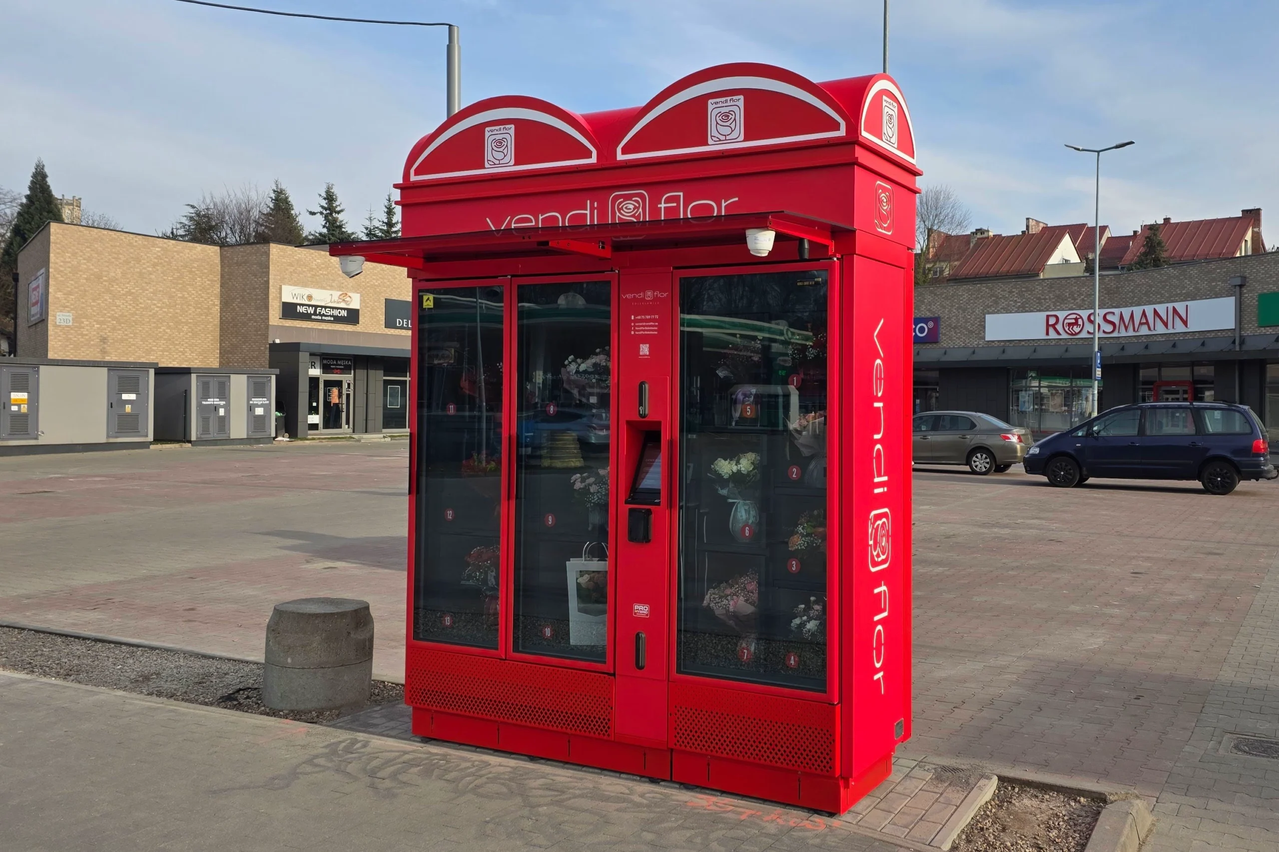 Czerwony kwiatomat VendiFlor z bukietami kwiatów ustawiony na placu handlowym w Bolesławcu