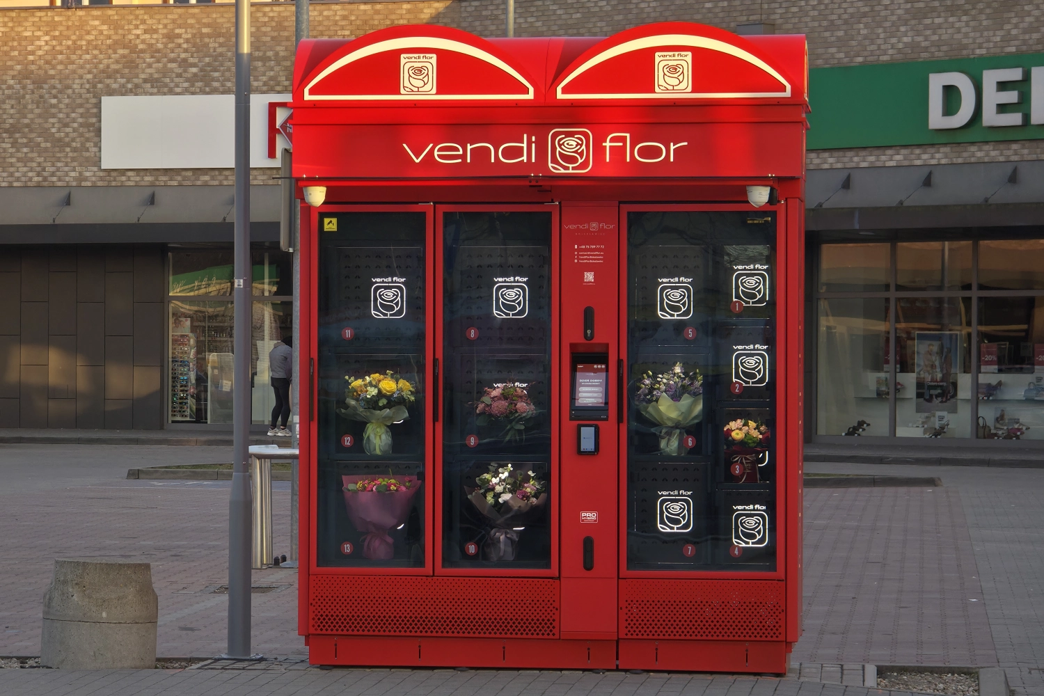 Modern red VendiFlor BouquetMat located in front of a shopping center with fresh flower bouquets available 24/7.