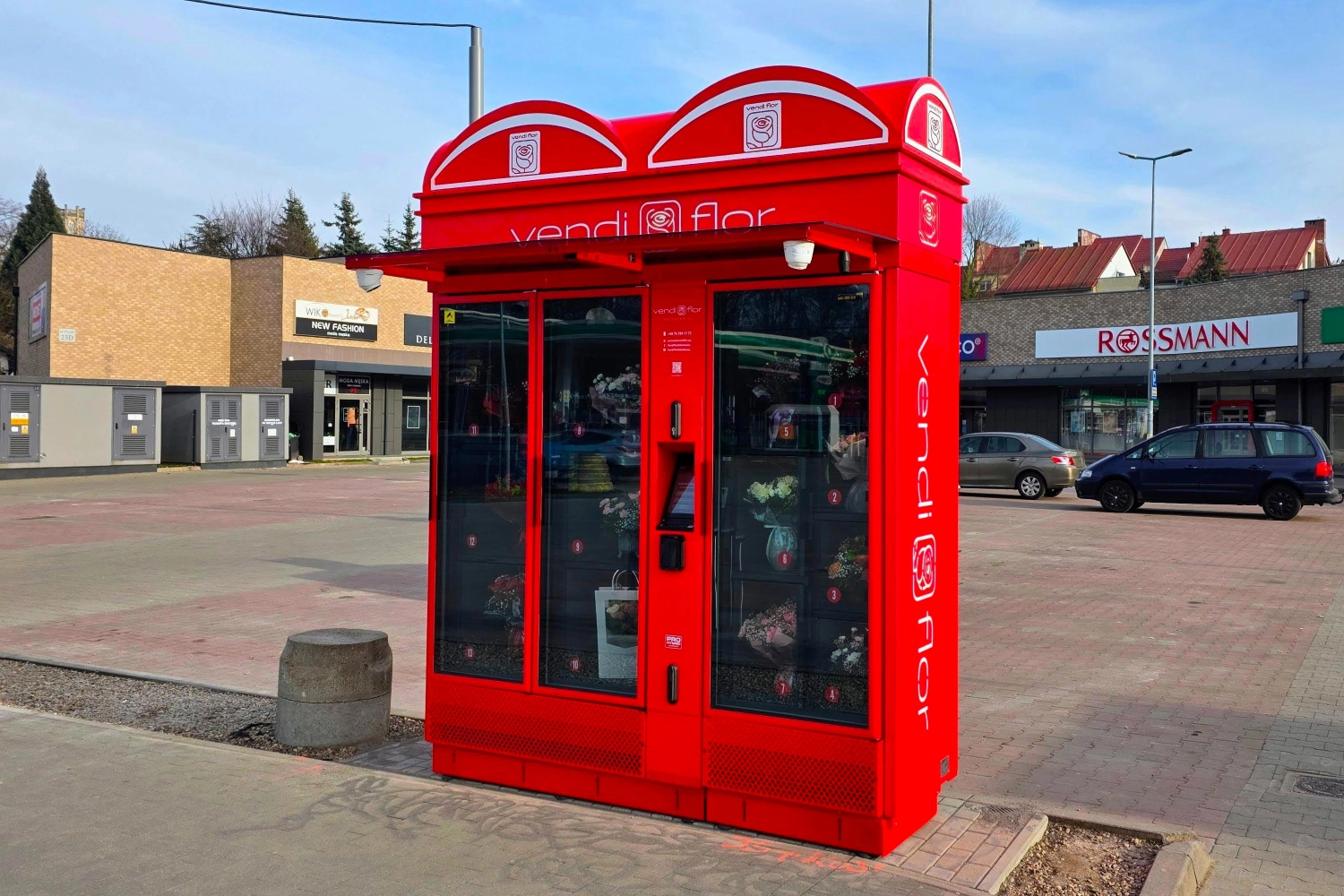 Red VendiFlor flower vending machine with illuminated advertising lightboxes and side branding, showcasing the customization possibilities of modern flower vending machines.